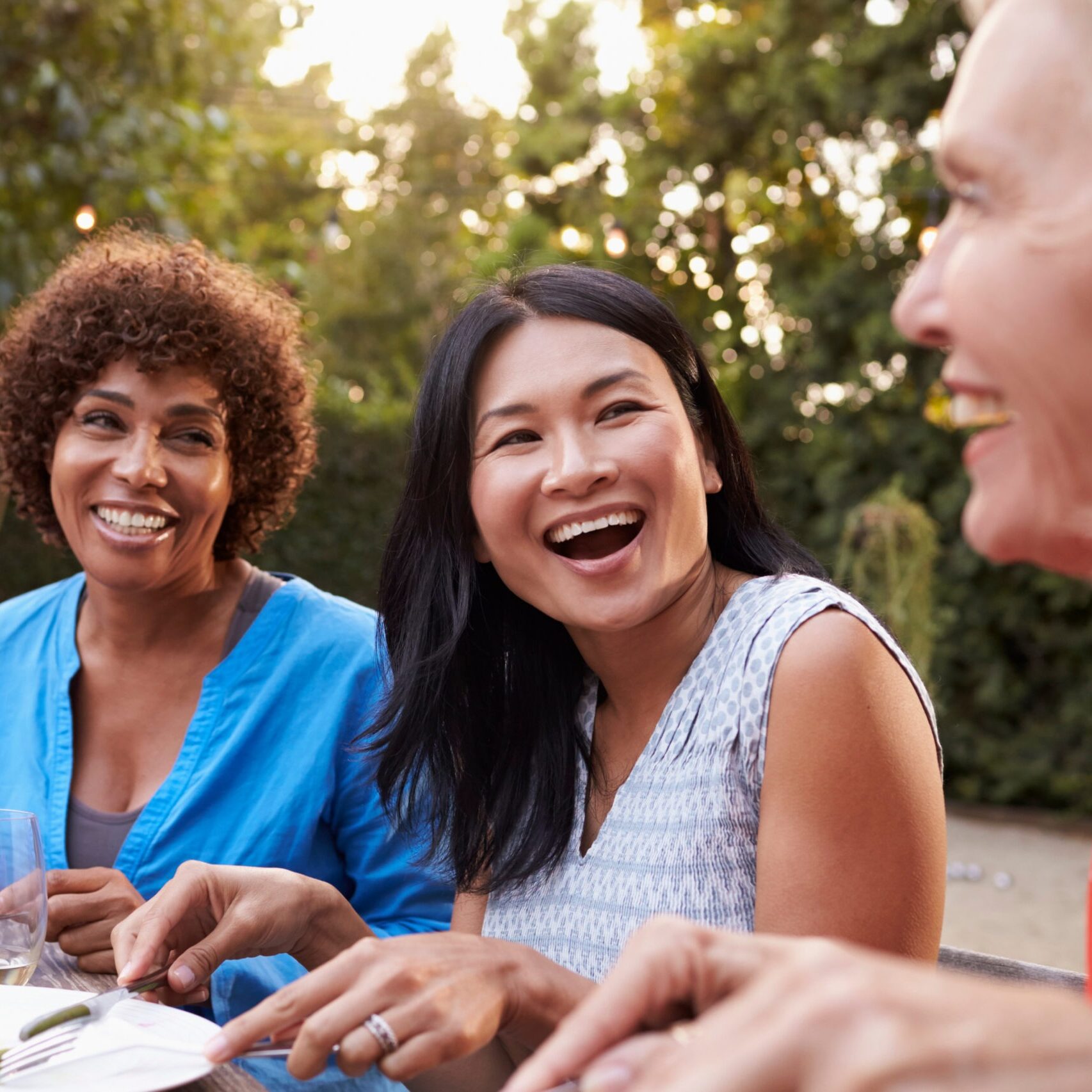 Mature Female Friends Enjoying Outdoor Meal In Backyard